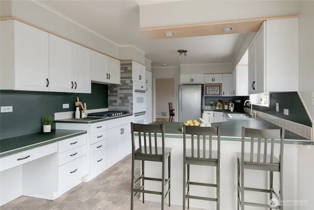 a kitchen with granite countertop white cabinets and stainless steel appliances