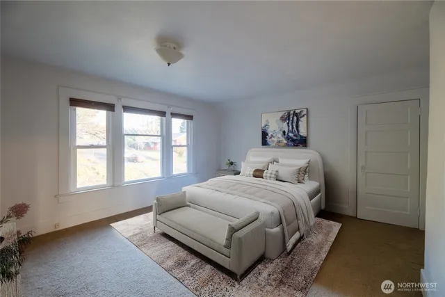 a bedroom with a bed lamp and a window