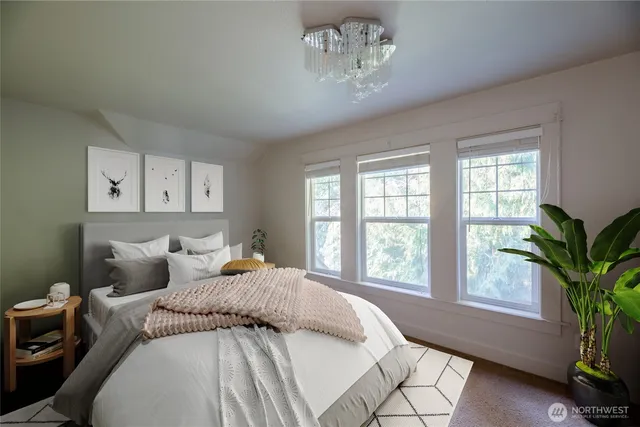 a bedroom with a large bed and a potted plant