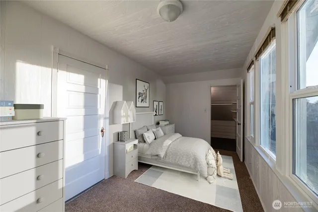 a bedroom with a bed and a large window