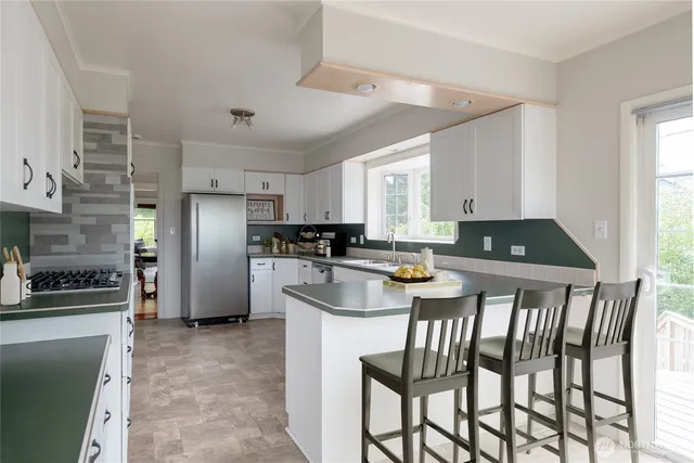 a kitchen with a table chairs refrigerator and microwave
