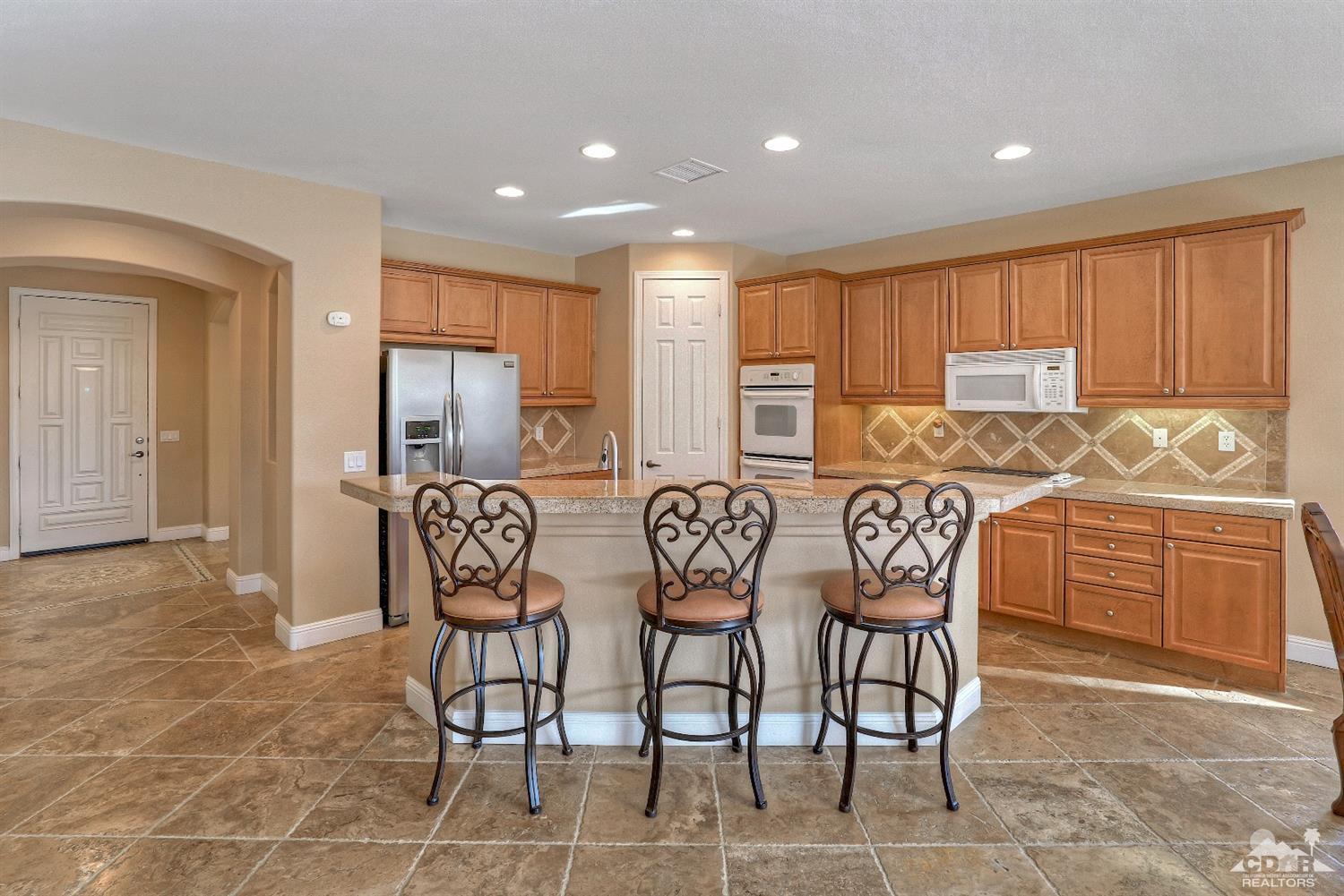 186 Via Milano Rancho Mirage, CA 92270 - Photo 10 of 24 a kitchen with stainless steel appliances kitchen island granite countertop a refrigerator and cabinets