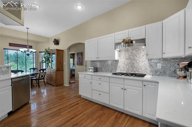 a view of a dining room with furniture a chandelier and window