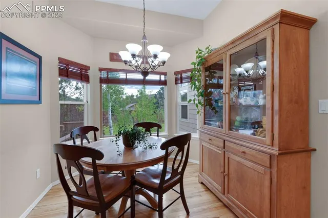 a dining room with furniture a chandelier and wooden floor