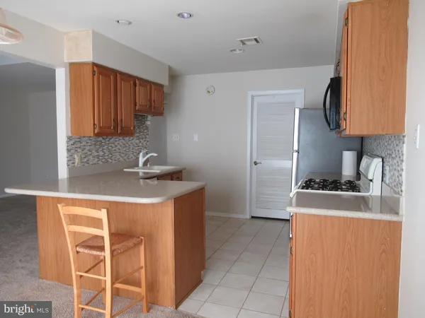 a kitchen with stainless steel appliances a microwave a stove and white cabinets