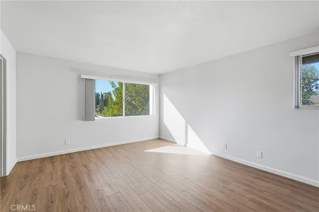 a view of an empty room with wooden floor