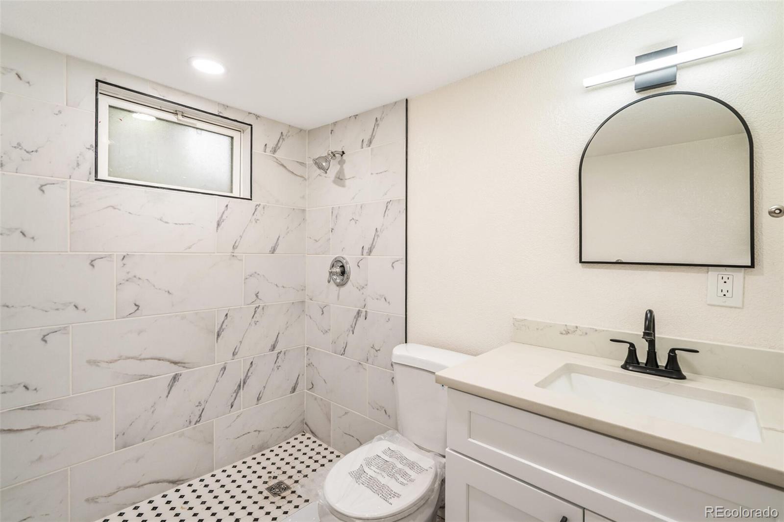 2040 Mable Avenue Denver, CO 80229 - Photo 15 of 25 a bathroom with a sink toilet and shower