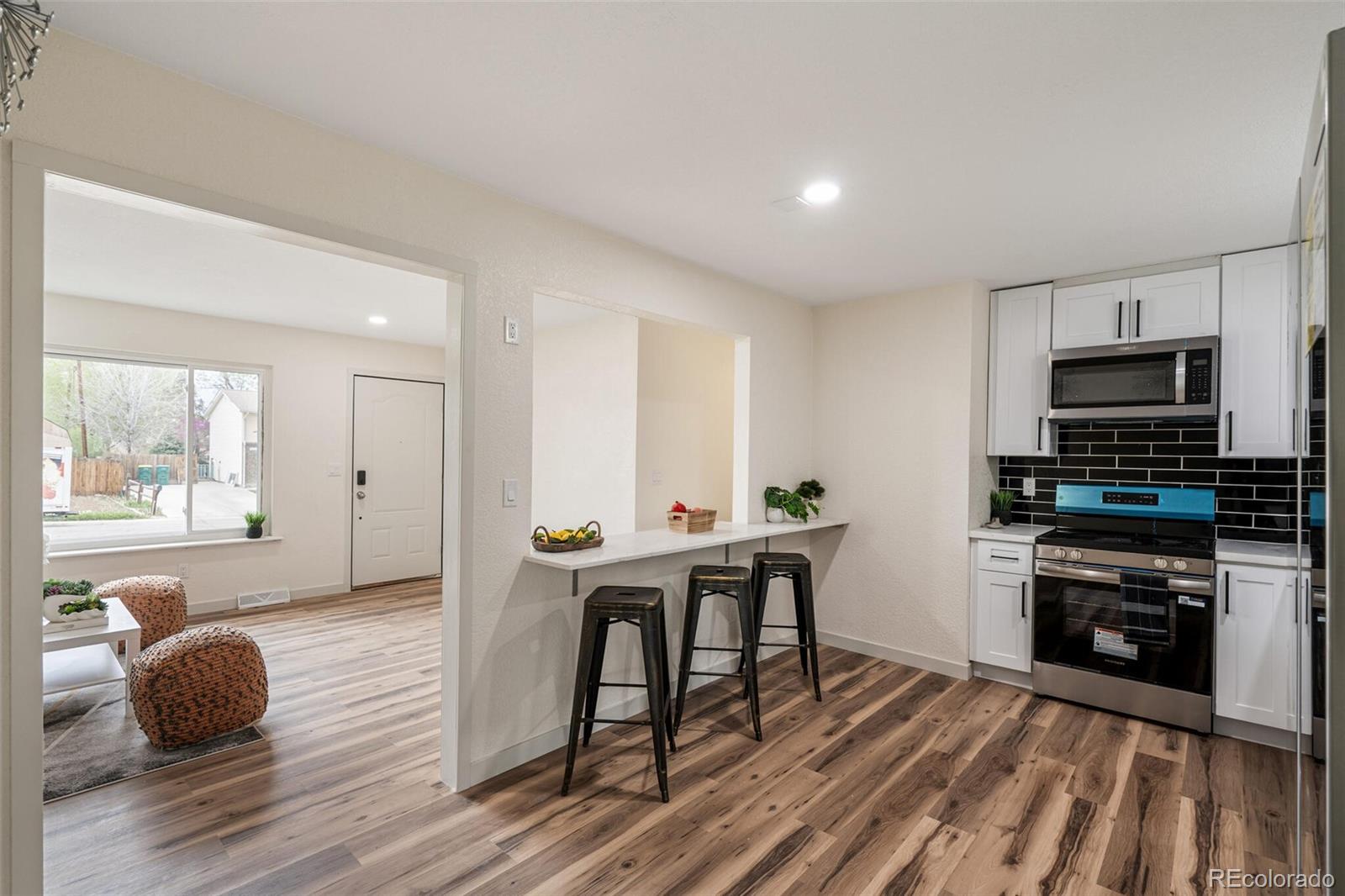 2040 Mable Avenue Denver, CO 80229 - Photo 5 of 25 a kitchen with stainless steel appliances granite countertop a stove top oven a sink dishwasher and cabinets with wooden floor