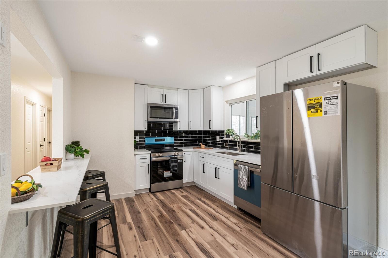 2040 Mable Avenue Denver, CO 80229 - Photo 6 of 25 a kitchen with stainless steel appliances granite countertop a refrigerator stove microwave and sink