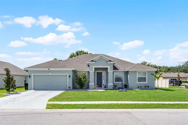 a front view of a house with a garden and yard