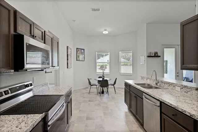 a kitchen with stainless steel appliances granite countertop a sink stove and refrigerator