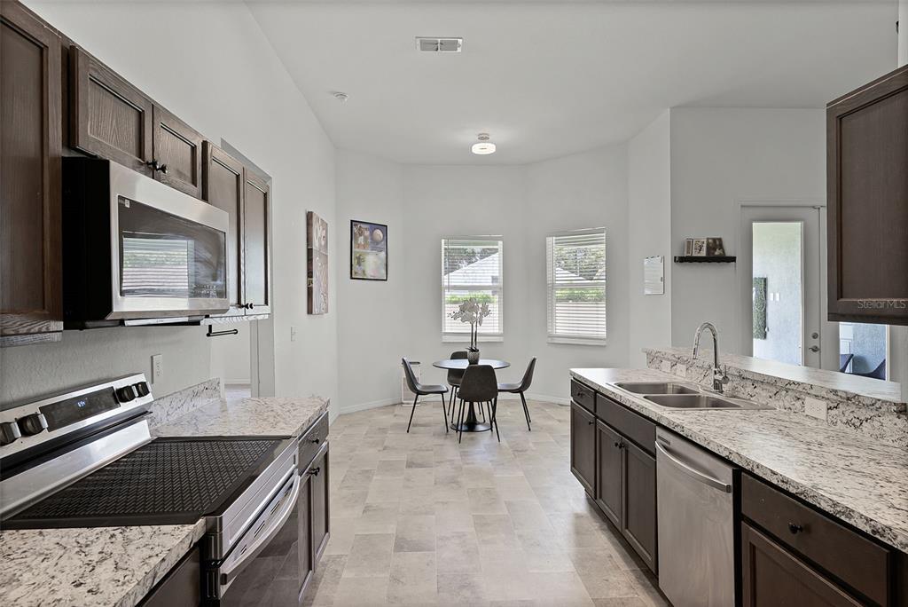 804 Channing Street Winter Haven, FL 33880 - Photo 11 of 31 a kitchen with stainless steel appliances granite countertop a sink stove and refrigerator