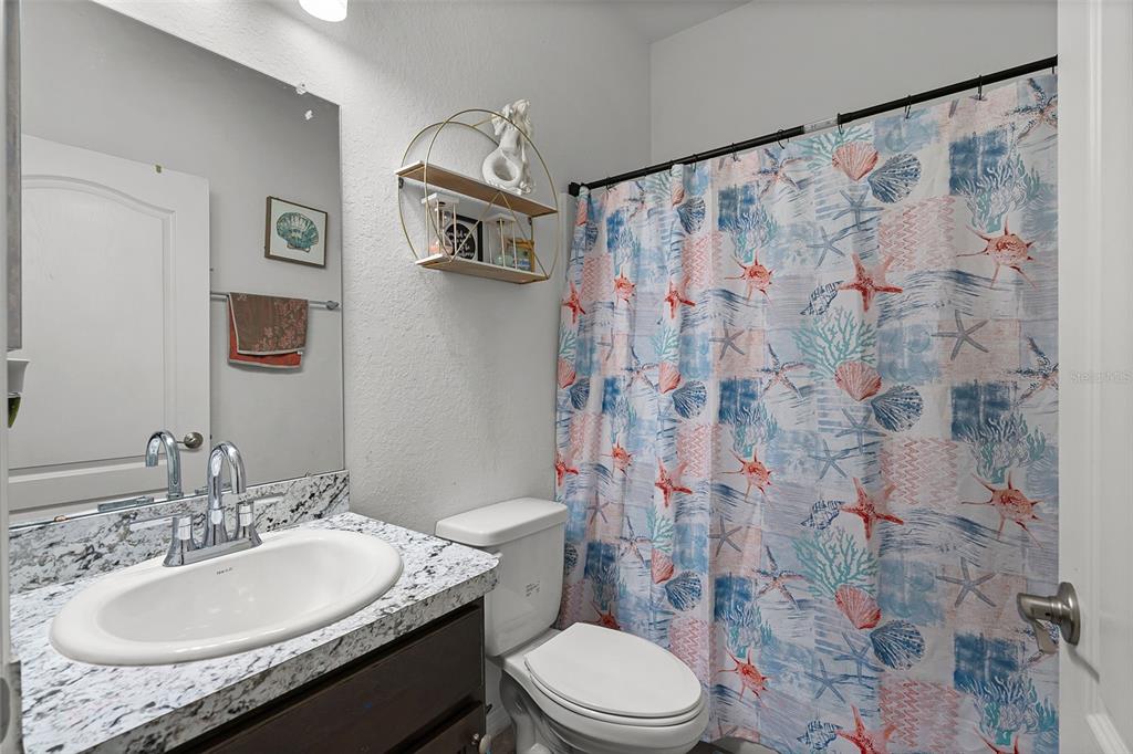 804 Channing Street Winter Haven, FL 33880 - Photo 23 of 31 a bathroom with a granite countertop sink toilet and shower