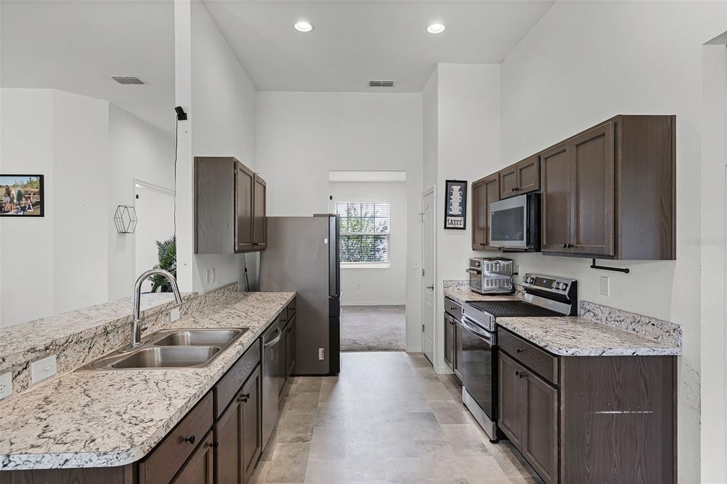 804 Channing Street Winter Haven, FL 33880 - Photo 10 of 31 a kitchen with stainless steel appliances granite countertop a sink stove and refrigerator