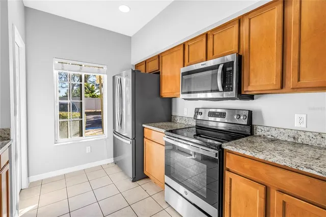 a kitchen with granite countertop a stove top oven and cabinets