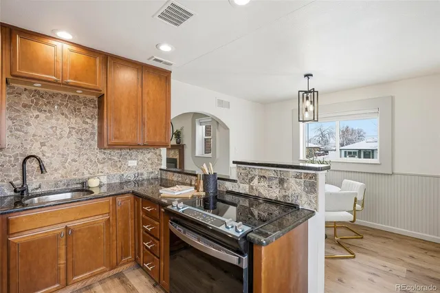 a kitchen with furniture a sink a window and stainless steel appliances