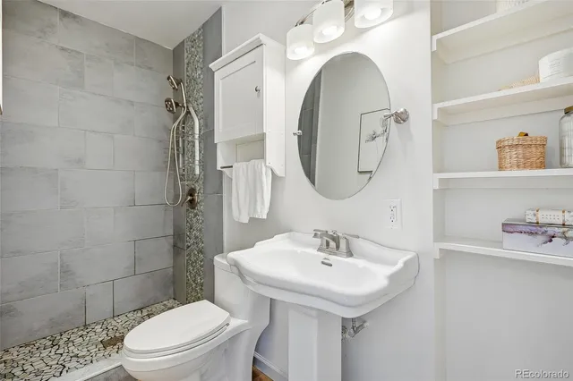 a bathroom with a sink a toilet and a mirror