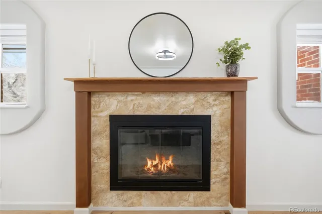 a living room with a fireplace and a potted plant