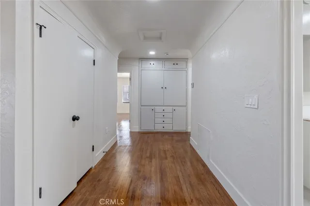 a view of an empty room with cabinet and a window
