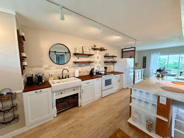 a kitchen with stainless steel appliances granite countertop a stove refrigerator and a sink