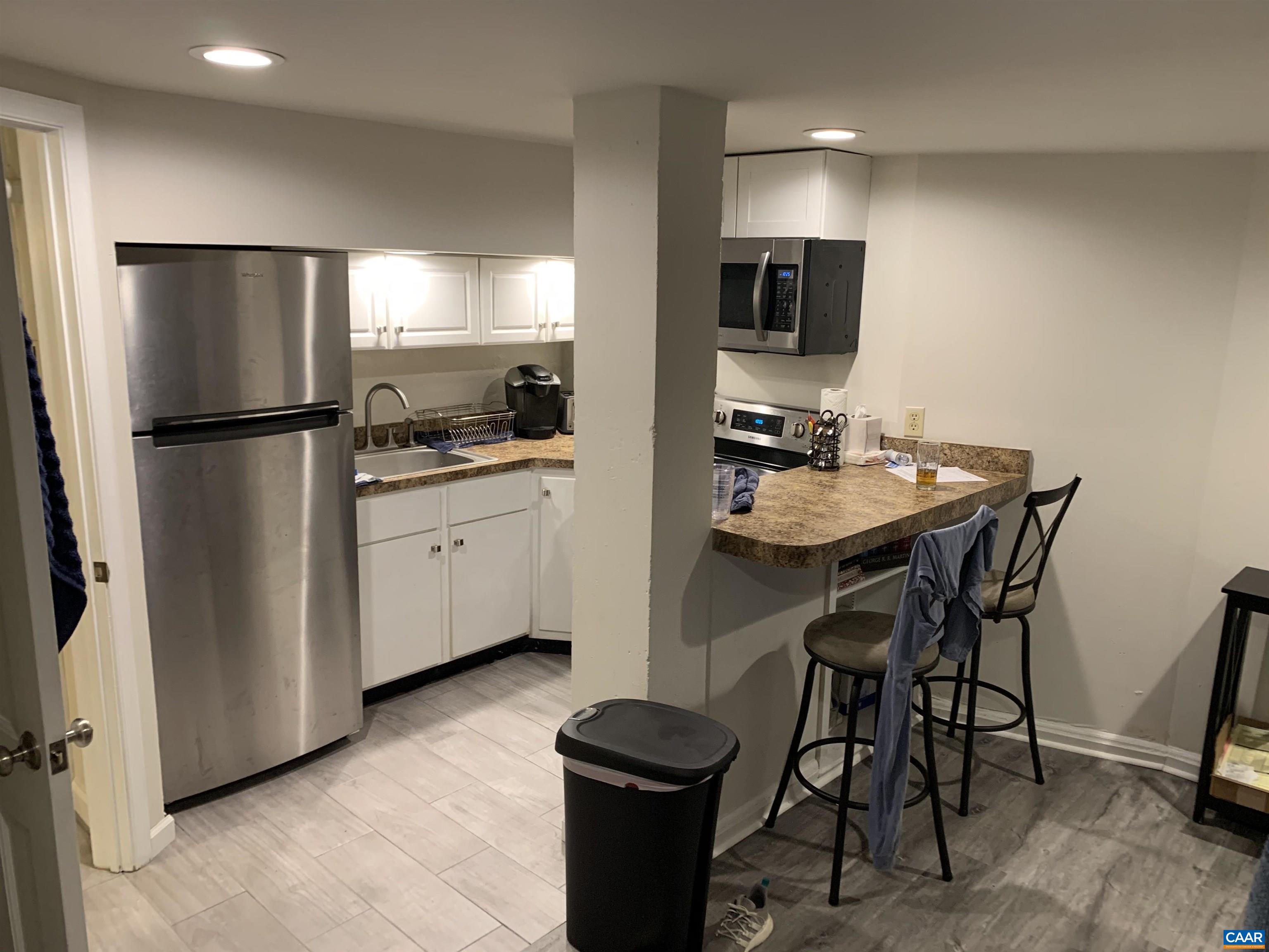 1407 Grady Avenue, Unit D Charlottesville, VA 22903 - Photo 3 of 14 a kitchen with a table chairs refrigerator and microwave
