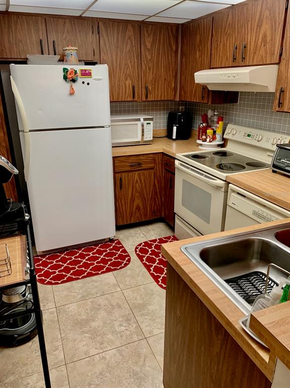 3006 Caring Way, Unit 417 Port Charlotte, FL 33952 - Photo 11 of 24 a kitchen with a refrigerator and a stove top oven