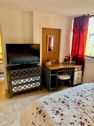 a bedroom with furniture and flat screen tv