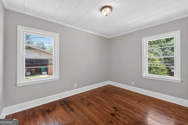 a view of a livingroom with wooden floor and a window