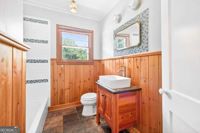 a large kitchen with stainless steel appliances granite countertop a refrigerator a sink dishwasher a dining table and chairs with wooden floor