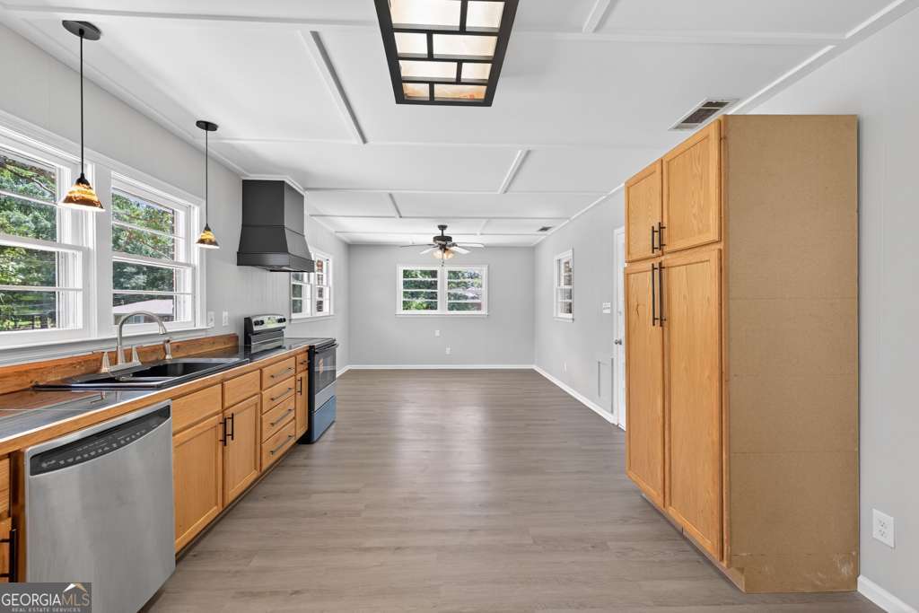 150 Jefferson River Road Athens, GA 30607 - Photo 31 of 76 a large kitchen with stainless steel appliances granite countertop a refrigerator a sink dishwasher a dining table and chairs with wooden floor