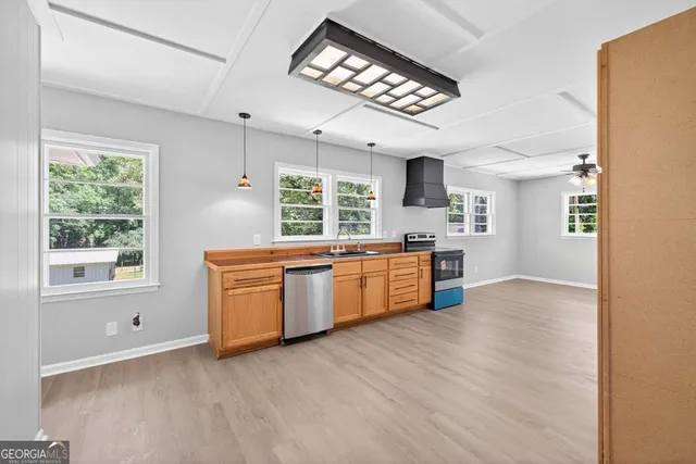 a kitchen with stainless steel appliances granite countertop a stove a sink and a microwave