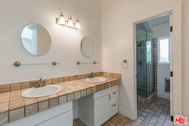 a bathroom with a granite countertop sink a mirror and a light fixture
