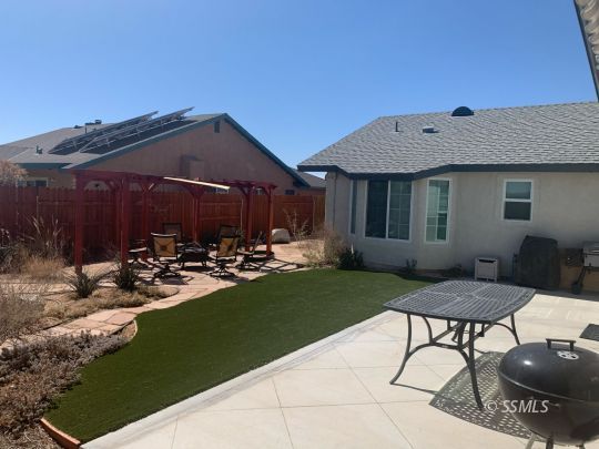 600 South Erin Street Ridgecrest, CA 93555 - Photo 35 of 39 a view of a backyard with table and chairs potted plants and a bench