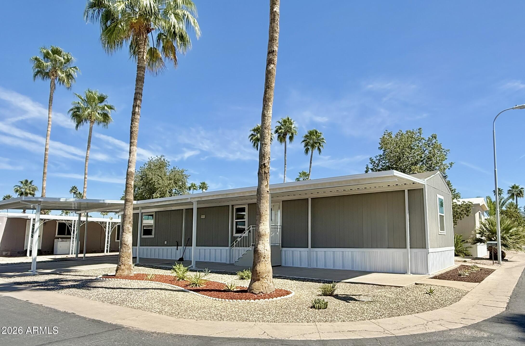 a view of a house with a yard and potted plants
