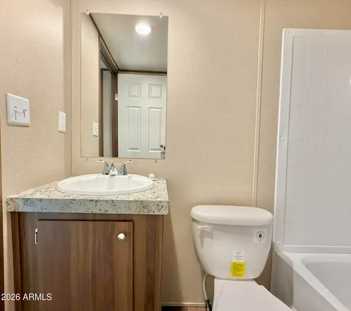 a bathroom with a granite countertop sink a toilet and a mirror
