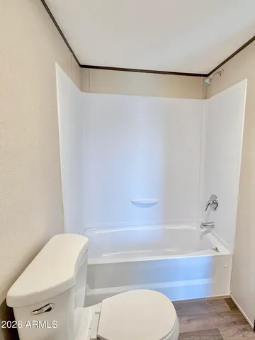 a view of a big room with wooden floor and windows