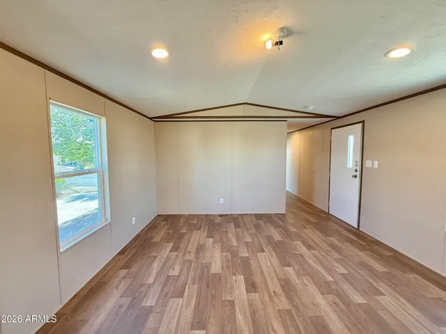 a view of a big room with wooden floor and windows