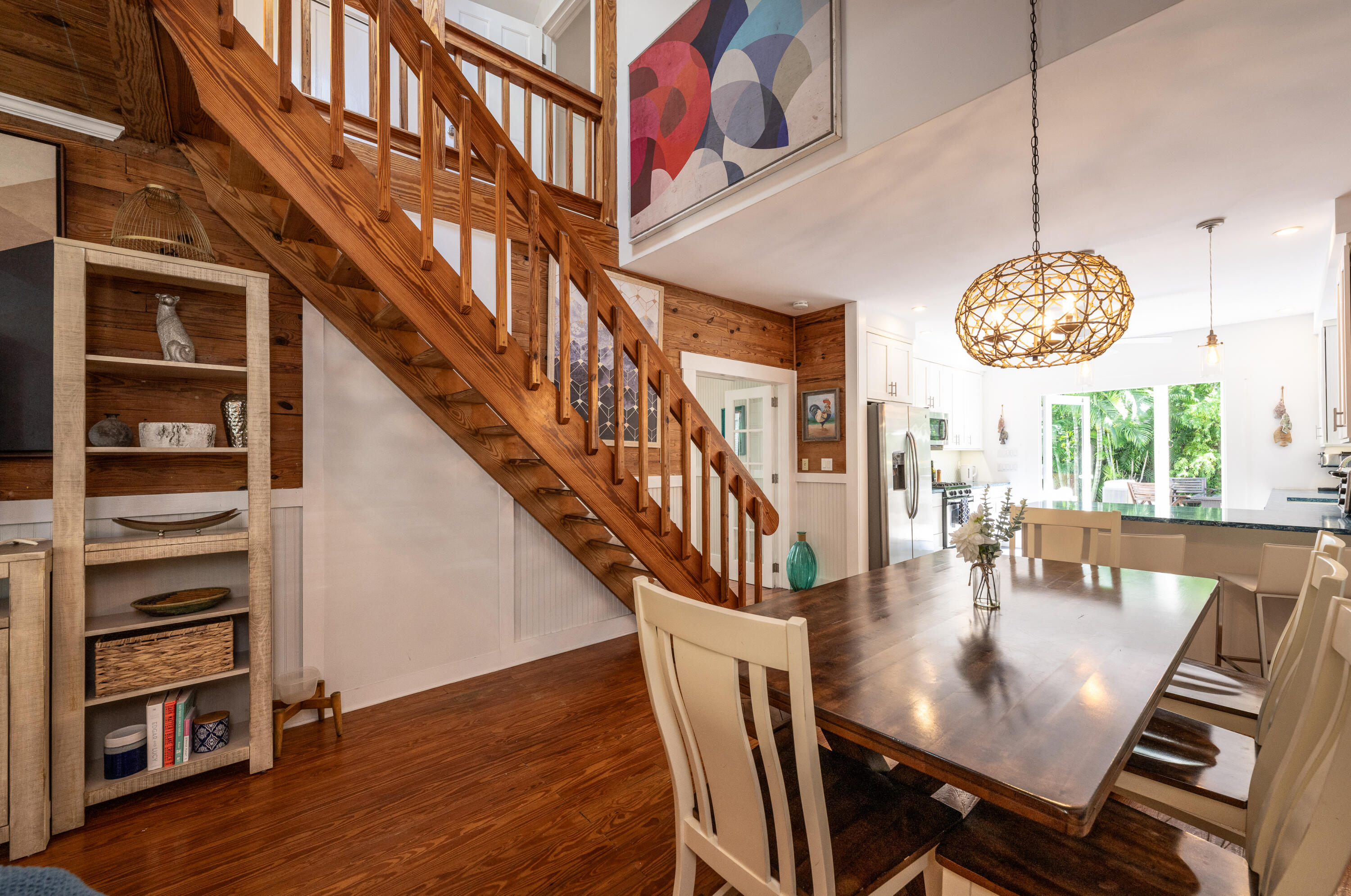 a view of a dining room with furniture a chandelier and wooden floor