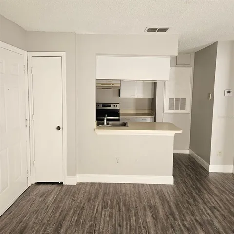 a view of a kitchen with wooden floor and a sink