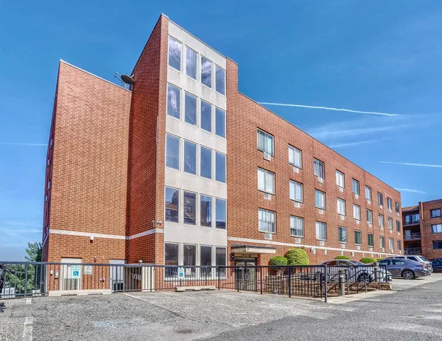 a front view of a building with lot of cars parked