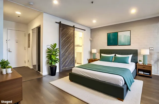 a spacious bedroom with a bed and a potted plant