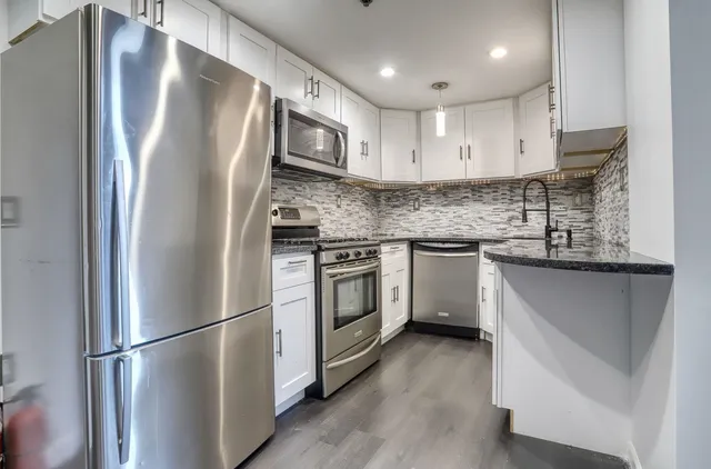 a kitchen with stainless steel appliances cabinets a refrigerator and a sink