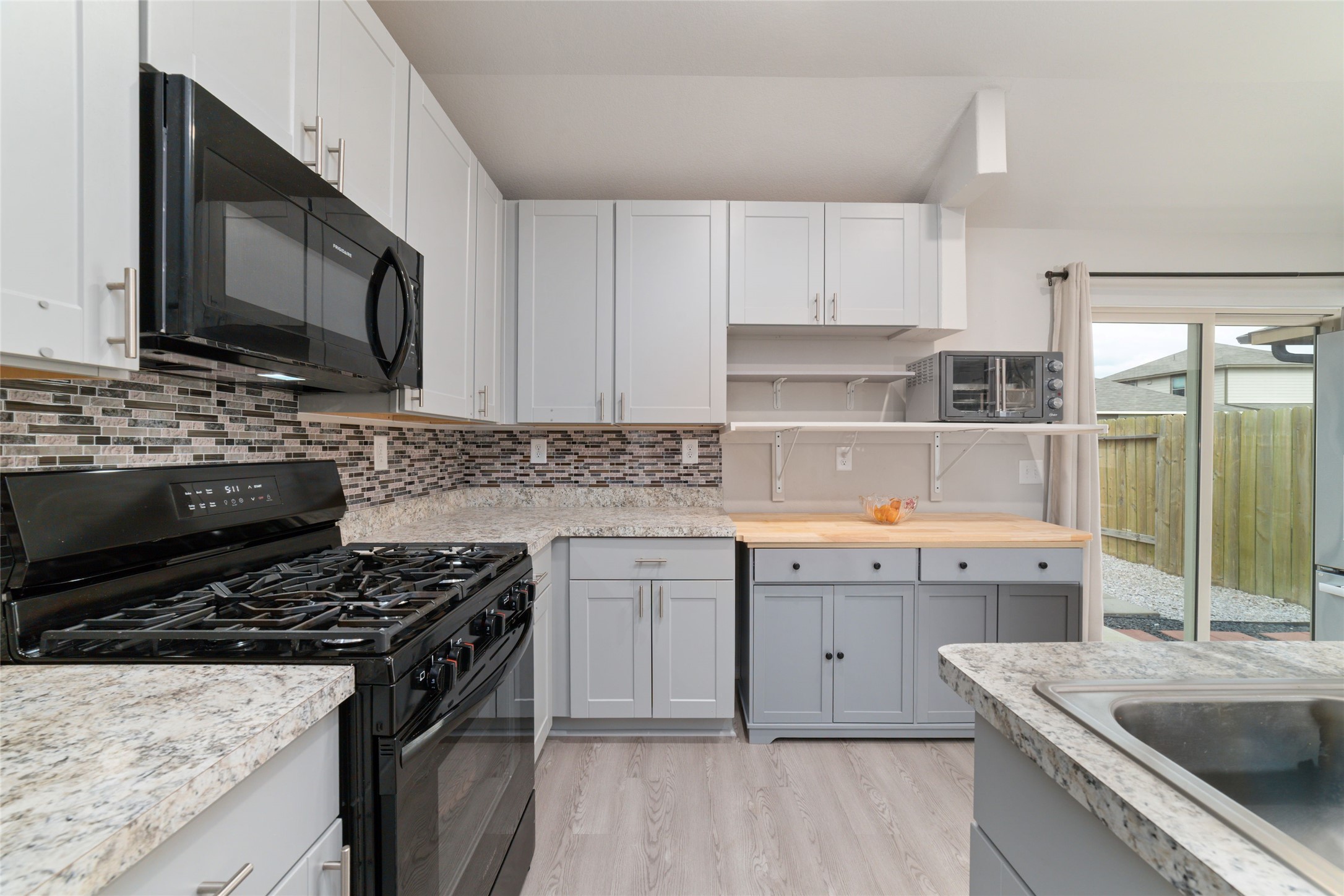 14232 Shasta Ridge Drive Conroe, TX 77303 - Photo 9 of 26 Bright kitchen with ample cabinetry and natural light, offering a functional layout that flows easily to the dining area and outdoor access.