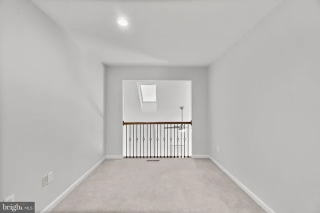 an empty room with a ceiling fan and a window