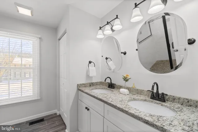 a bathroom with a granite countertop sink and a mirror