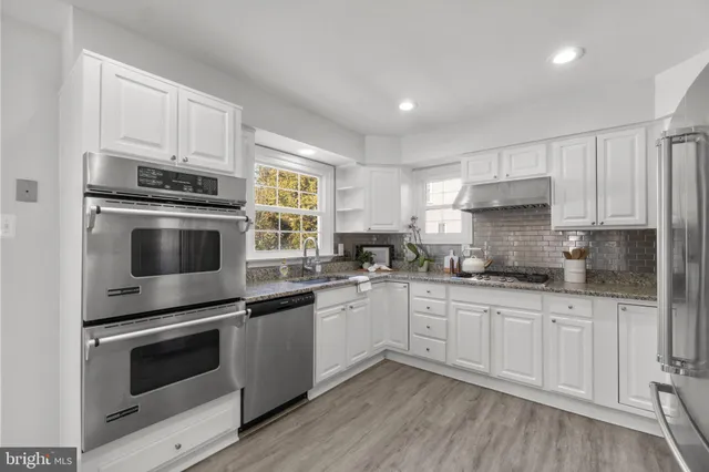 a kitchen with stainless steel appliances and white cabinets