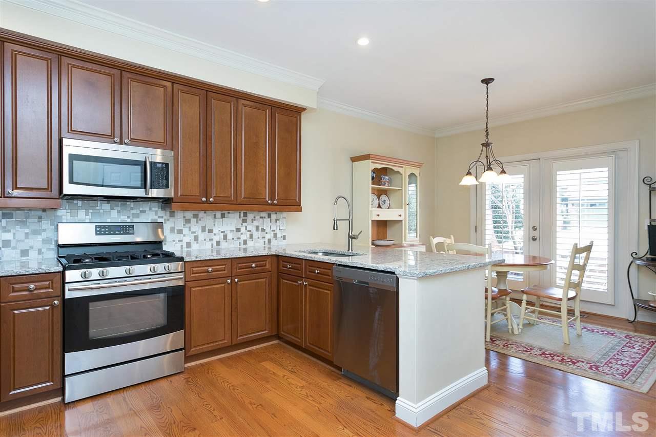 Kitchen with updated granite and backsplash and SS appliances including gas range.