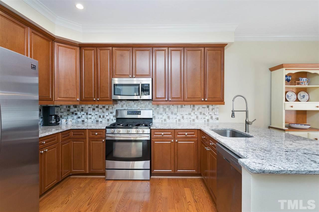 Well-lit kitchen with lots of cabinets and pantry.