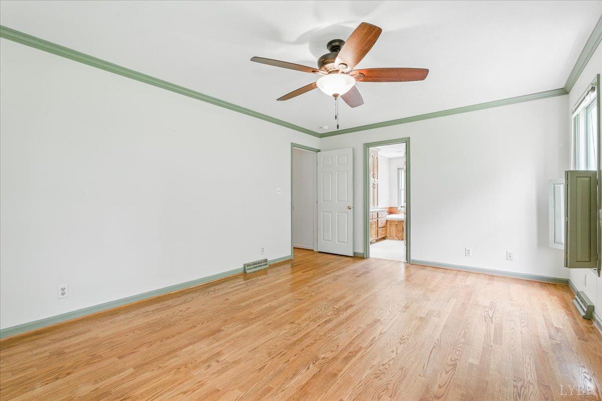 530 Patteson School Road Appomattox, VA 24522 - Photo 20 of 45 an empty room with wooden floor fan and windows
