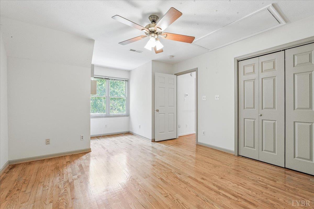530 Patteson School Road Appomattox, VA 24522 - Photo 29 of 45 an empty room with wooden floor chandelier fan and windows